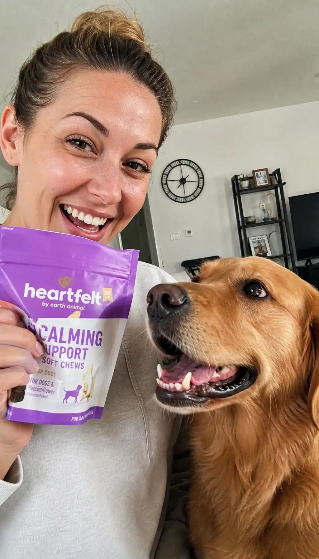Woman with a golden retriever holding a bag of calming dog chews